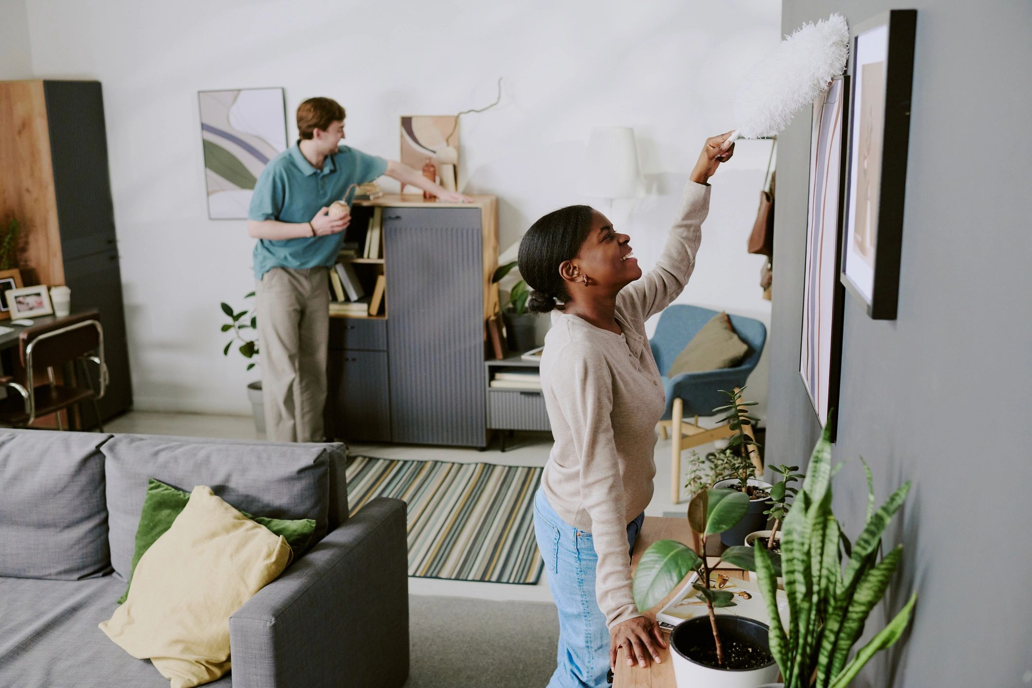 Black woman tidying and cleaning a living room